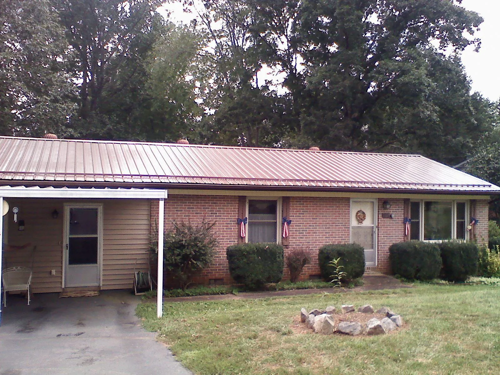 Bronze metal roof and carport on a brick ranch home — Roof Repair work by our crew in Hebron